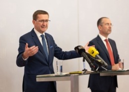 Markus Achleitner vor einem Rednerpult mit Mikrofonen