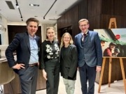 Vier Personen stehen nebeneinander und lächeln in die Kamera.