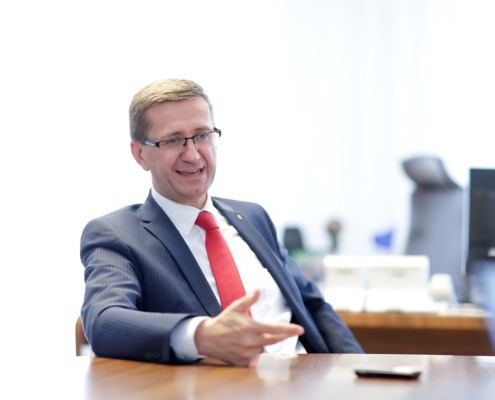 Ein Herr sitzt am Schreibtisch und redet.