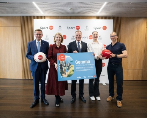Viele Menschen stehen vor einer Sport Wand und halten ein großes Plakat in der Hand.