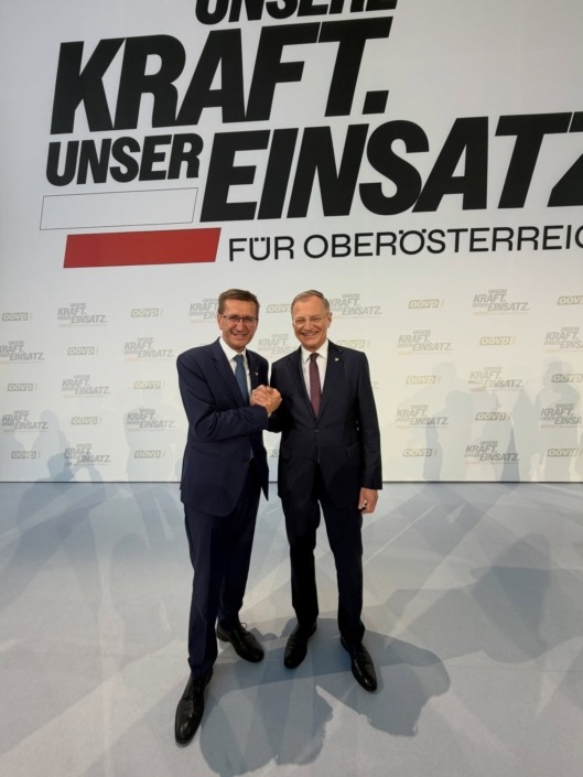 Landeshauptmann Mag. Thomas Stelzer und Landesrat Markus Achleitner – © Land OÖ Zwei Männer in Anzügen und halten Hände.