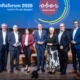 mehrere Personen stehen vor einer Oberösterreich Präsentation und lächeln in die Kamera.