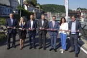 Sieben Personen stehen in Linz mit einem Band in der Hand.