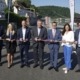 Sieben Personen stehen in Linz mit einem Band in der Hand.