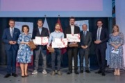 Jungforscher/innenpreis an Jan Zesinek, Bernhard Blank-Landeshammer und Philip Kastner vergeben – v.l.: Wirtschafts- und Forschungs-Landesrat Markus Achleitner, MMag.a Isolde Perndl, Kaufmännische Geschäftsführerin FH OÖ, Jan Zesinek, Bernhard Blank-Landeshammer, Philip Kastner, Dr. Johann Kastner, Vizepräsident für F&E, Dr. Michael Rabl, Hochschulpräsident FH OÖ, Sandra Mühlböck, Moderation. Viele Menschen stehen auf einer Bühne und halten drei Zeugnisse in der Hand.