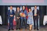 Habilitation für FH-Assistenzprof. Sascha Senck – v.l.: Wirtschafts- und Forschungs-Landesrat Markus Achleitner, Dr. Johann Kastner, Vizepräsident für F&E, Sascha Senck, MMag.a. Isolde Perndl, Kaufmännische Geschäftsführerin FH OÖ, und Dr. Michael Rabl, Hochschulpräsident FH OÖ Fünf Menschen stehen auf einer Bühne und halten ein Geschenk in der Hand.