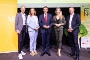 Bei der Upper Food 2026 (v. l.): Andreas Haider (Unigruppe GmbH, Lebensmittel-Cluster-Beiratssprecher), Heidrun Hochreiter (Lebensmittel-Cluster-Managerin, Business Upper Austria), Wirtschafts-Landesrat Markus Achleitner, Moderatorin Theresa Breiteneder, Christian Altmann (Business Upper Austria) Fünf Personen stehen auf einer Bühne. Sie sind elegant gekleidet und lächeln in die Kamera.
