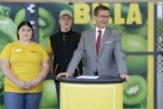 v.l.: BILLA-Lehrling Marie Hartinger, BILLA-Lehrling Robert Hacker, Wirtschafts-Landesrat Markus Achleitner. Ein Mann steht vor einem Pult im Anzug angezogen. Er spricht ins Publikum.
