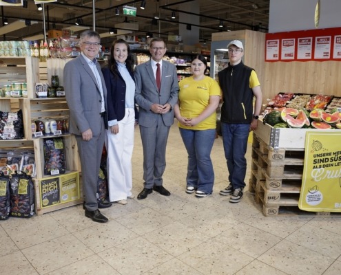 Fünf Personen stehen in einem Billa Markt und lächeln in die Kamera.