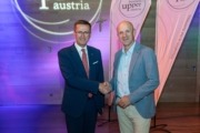 Zwei Herren geben sich die Hand und sind elegant gekleidet.