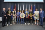 v.l.: Landeshauptmann Mag. Thomas Stelzer, Christian von Fintel (Raiffeisen Flyers Wels), Carmen Raab (Linz AG Steelvolleys), Peter Zauner (ASKÖ Traun), Laura Priemetshofer (Union Compact Freistadt), Felix Wetzel (SPG Felbermayr Wels), Robert Renner (Linz AG Froschberg), Karl Müllehner (Union Tigers Vöcklabruck), Wirtschafts- und Sport-Landesrat Markus Achleitner. Viele Personen stehen vor vielen Flaggen und halten Preise in der Hand.