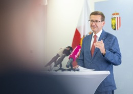 Ein Herr steht an einem Redepult und spricht ins Mikrofon.