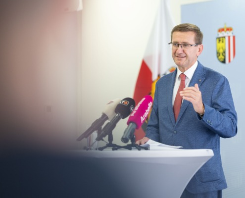 Ein Herr steht an einem Redepult und spricht ins Mikrofon.