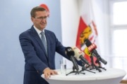 Wirtschafts-Landesrat Markus Achleitner Ein Herr steht an einem Pult mit Mikrofonen und spricht.
