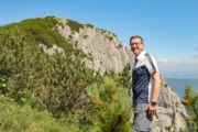 Wirtschafts- und Tourismus-Landesrat Markus Achleitner: „Oberösterreich punktet bei Gästen aus dem In- und Ausland insbesondere auch mit seiner beeindruckenden Landschaft.“ Ein Mann steht vor einem Berg und deutet auf die Natur.