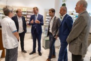 Sechs Personen sprechen in einem Geschäft miteinander.