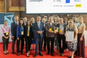 Sonderpreis der Jury: HOP – Next Stop: Your Job: Vertreterinnen und Vertreter von Airport Linz, Dachser, Elmet, TRUMPF und Wacker Neuson mit Wirtschafts-Landesrat Markus Achleitner (Mitte), Business-Upper-Austria-Geschäftsführer Werner Pamminger (2. v. l.) und HCM-Beiratssprecherin Martina Hamedinger (r.). Die Projektinitiatoren Thomas Brückl (TRUMPF) und Harald Pühringer (Wacker Neuson) halten den Preis in den Händen. Viele Menschen stehen nebeneinander und halten Urkunden in der Hand.