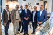 Sechs Herren stehen elegant gekleidet vor der Kamera und lächeln.
