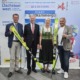 Vier Personen stehen nebeneinander und halten ski in der Hand.