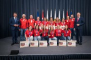 Viele Menschen stehen vor Flaggen und halten Preise in der Hand.