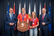 Vier Personen stehen vor einem Vorhang und machen Fotos.