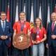 Vier Personen stehen vor einem Vorhang und machen Fotos.