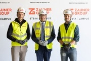 Drei Herren stehen vor einer Leinwand, einer von ihnen ist Landesrat Markus Achleitner. Alle drei tragen einen Helm und Schutzweste.