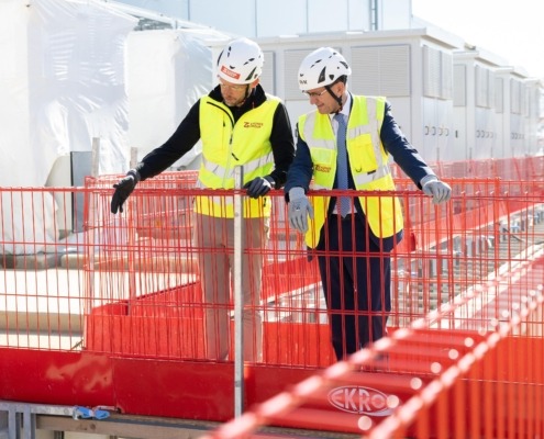 Landesrat Markus Achleitner besichtigt gemeinsam mit einem Mitarbeiter der Zauner Group eine Baustelle und informiert sich über den Baufortschritt.