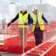 Landesrat Markus Achleitner besichtigt gemeinsam mit einem Mitarbeiter der Zauner Group eine Baustelle und informiert sich über den Baufortschritt.
